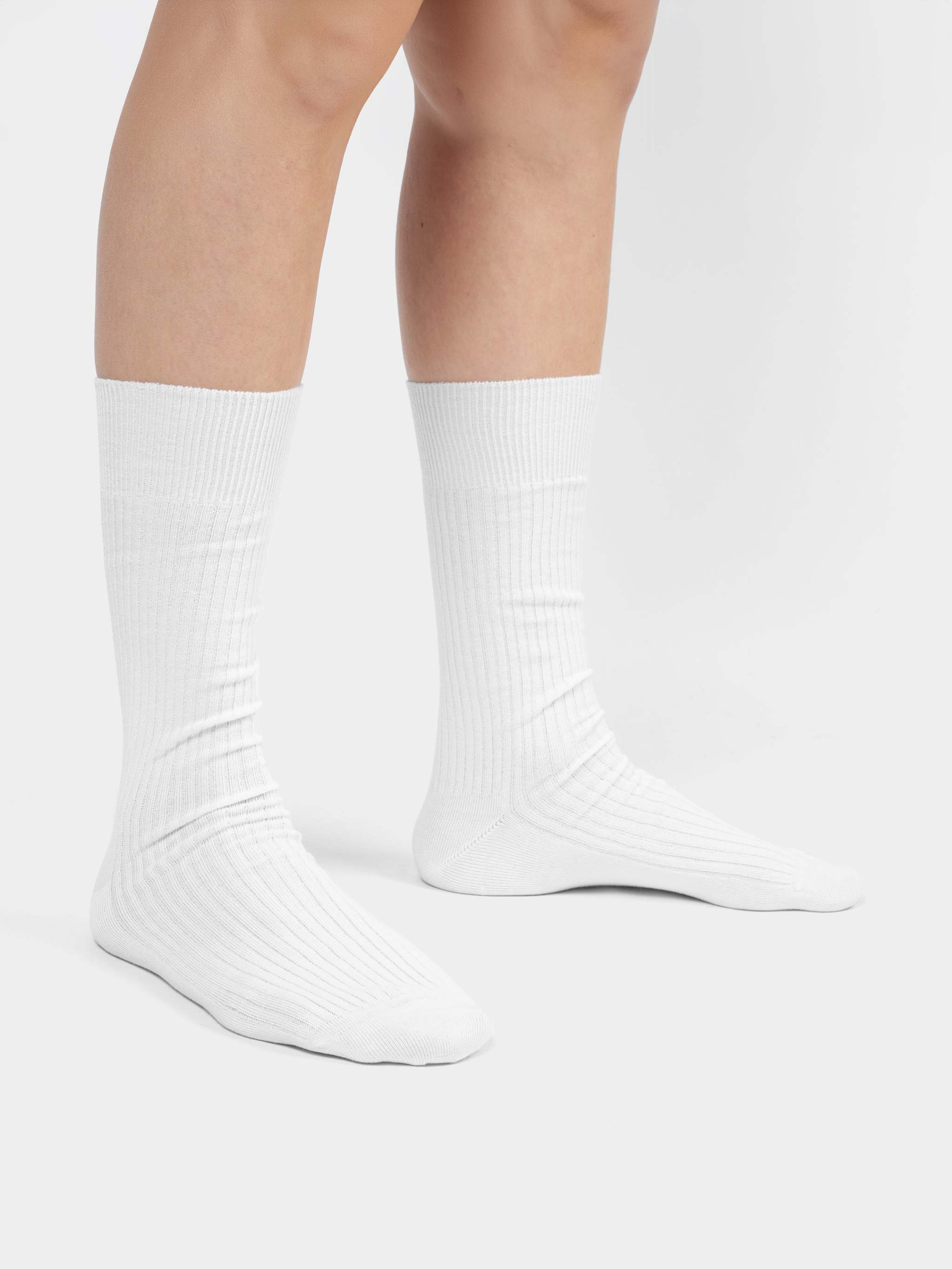 Rippenstrukturierte weiße Socke „Ribbed Snow White“ vor hellem Hintergrund