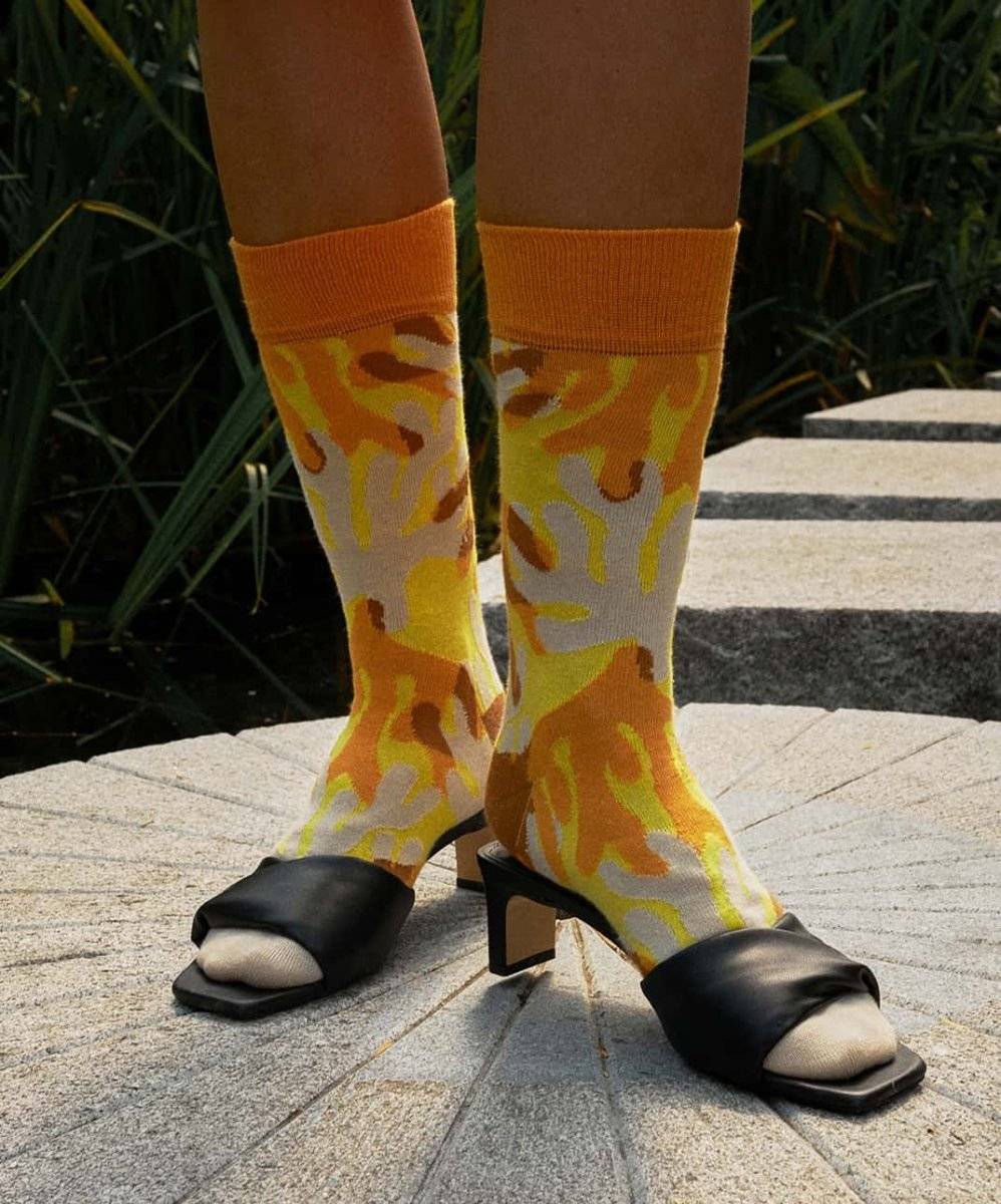 Bunte Sunshine Coral Socken mit Sonnenmotiv auf Korallenriff-Hintergrund